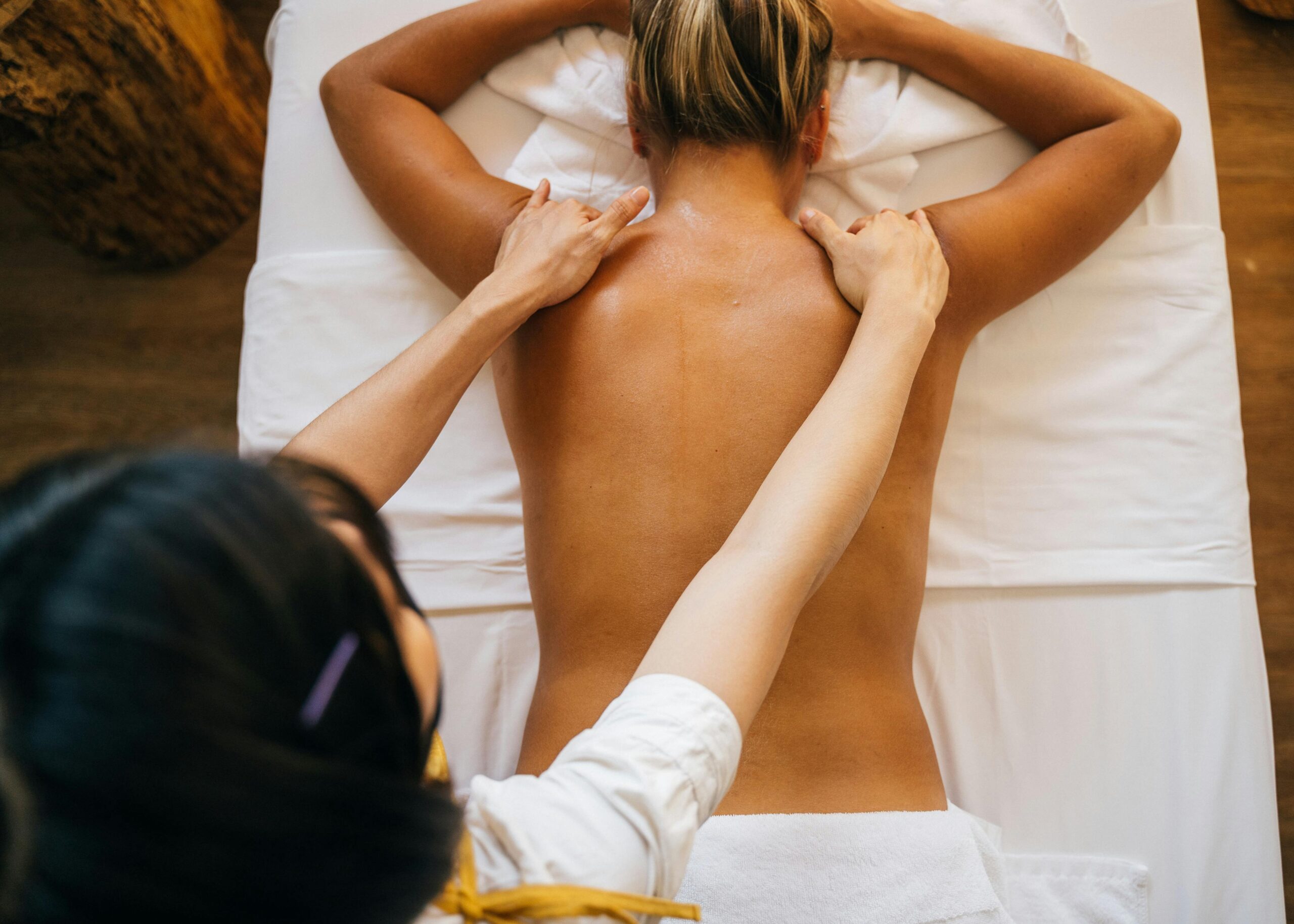 A woman receives a back massage in a spa, promoting relaxation and wellness.